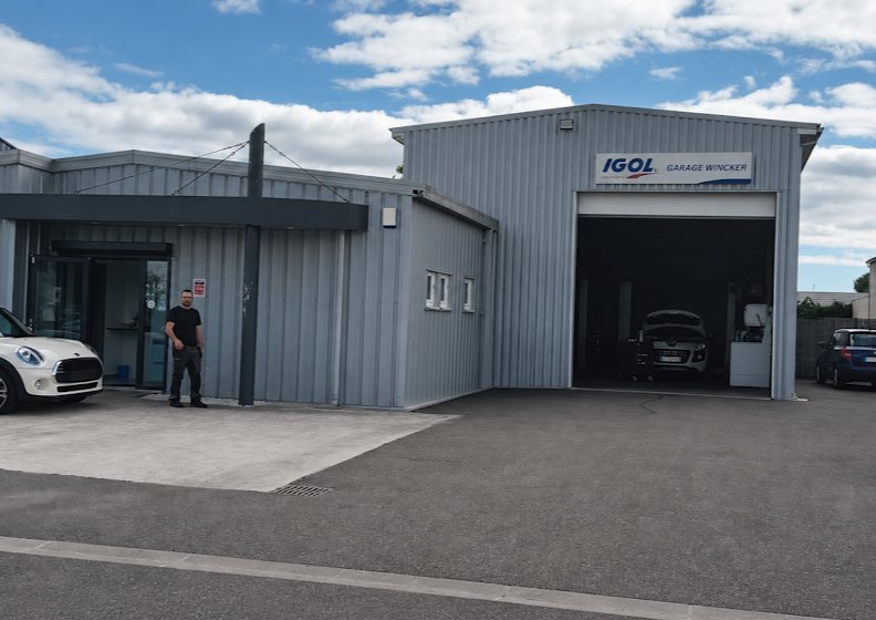 Façade de l’atelier du Garage Wincker à Cestas, porte de l’atelier ouverte sur un véhicule en intervention